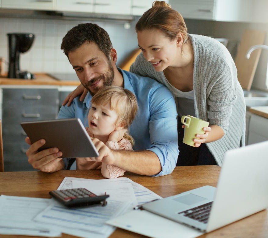 Family looking at a tablet at their kitchen